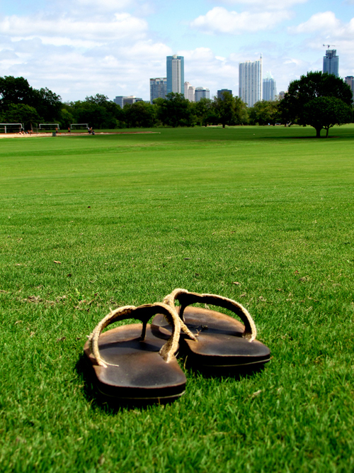 zilker park sandals hipster city skyline downtown grass field lawn